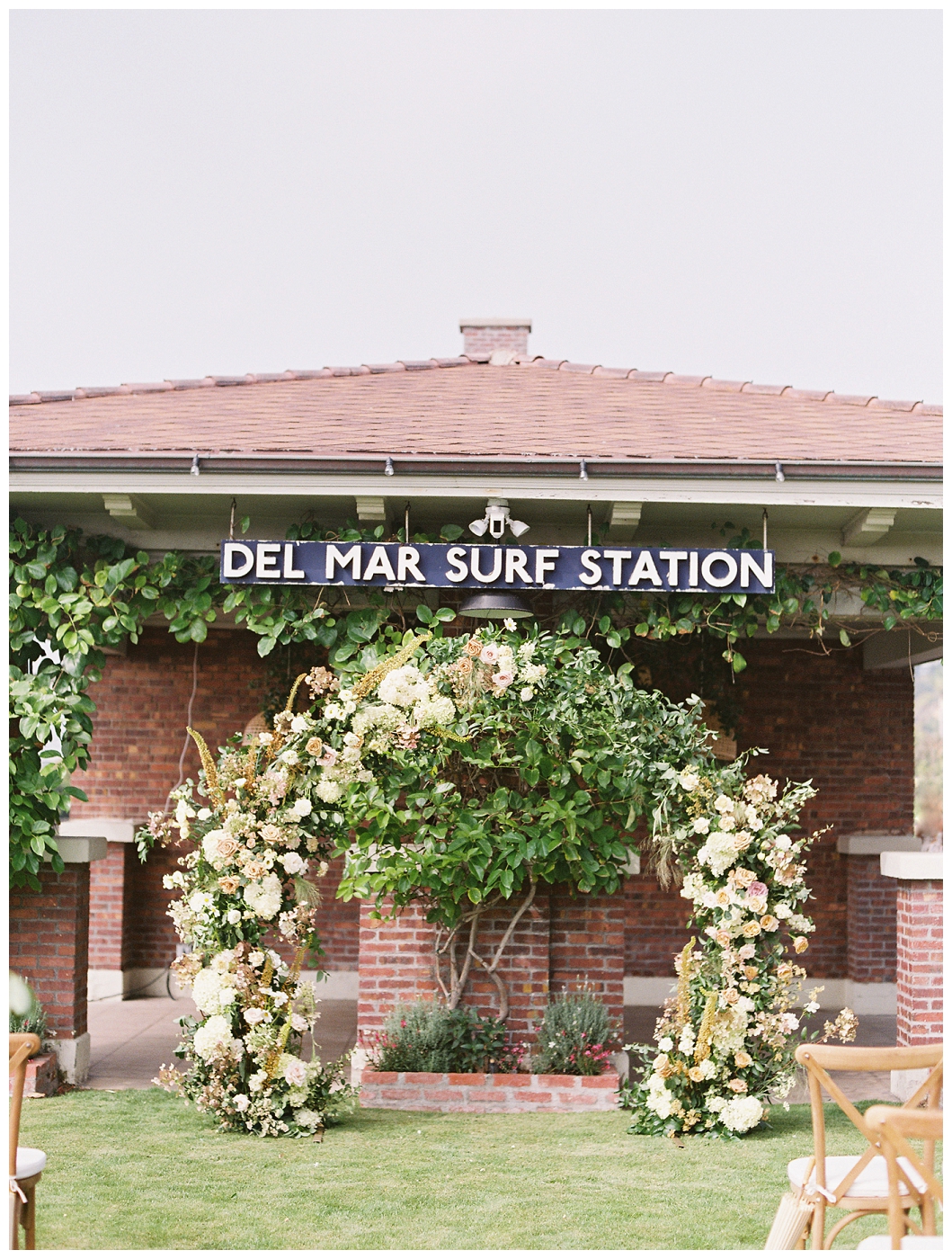 beautiful and lush wedding circle arch at beach venue del mar surf station with tons of flowers