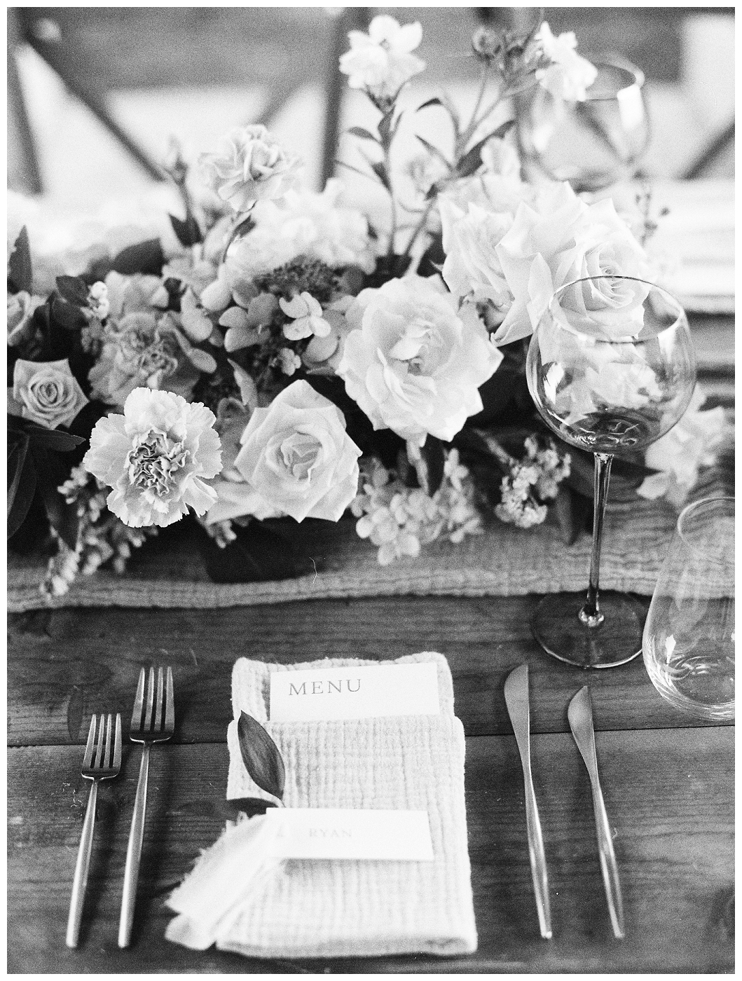 black and white photo of reception table place setting, del mar surf station, farmhouse table, budvases ,outdoor reception, medium sized centerpieces, romantic weddings, daisies, toffee roses, berries, cream flowers, white flowers, hydrangeas, majolica roses, explosion grass, outdoor wedding, covid wedding, san diego wedding florist, southern california elopement florist, socal florist, best wedding florist san diego ca, best wedding florist southern california, los angeles wedding florist, top rated wedding florist in california, del mar san diego, blush tapered candles, blush table runner, budvases