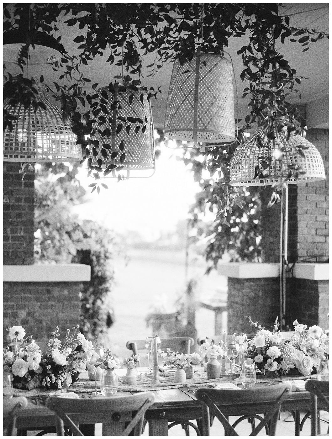 black and white photo of reception table with tapered candles and budvases outdoors, del mar surf station, farmhouse table, budvases ,outdoor reception, medium sized centerpieces, romantic weddings, daisies, toffee roses, berries, cream flowers, white flowers, hydrangeas, majolica roses, explosion grass, outdoor wedding, covid wedding, san diego wedding florist, southern california elopement florist, socal florist, best wedding florist san diego ca, best wedding florist southern california, los angeles wedding florist, top rated wedding florist in california, del mar san diego, blush tapered candles, blush table runner, budvases